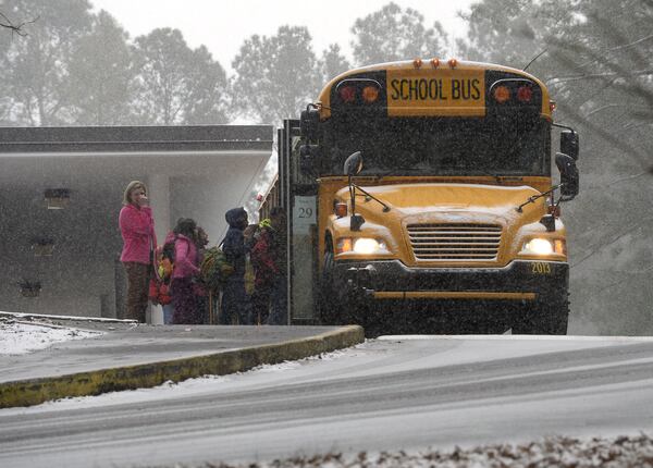 Sagamore Hills Elementary School students board a DeKalb County school bus for early dismissal as a major winter storm dumps 1 to 3 inches of snow on the metro Atlanta area, Tuesday, Jan. 28, 2014. David Tulis / AJC Special DAVID TULIS / AJC SPECIAL