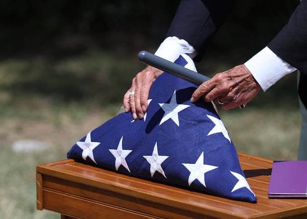 Deacon Glenn Tylutki, of Chicago Catholic Cemeteries, adjusts an American flag prior to a military funeral for 75-year-old Pfc. Reba C. Bailey, a former missing person cold case named Seven Doe, Tuesday, July 1, 2025, at Mount Olivet Catholic Cemetery in Chicago. (AP Photo/Talia Sprague)