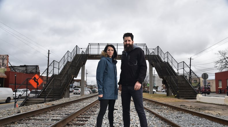 College Park residents Whitney (left) and Micah Stansell have been commissioned to tranform the Hapeville Pedestrian Bridge, visible in the background, into a public art installation. HYOSUB SHIN / HSHIN@AJC.COM