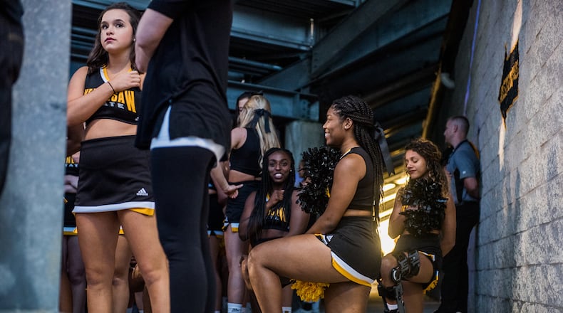 Three cheerleaders are seen kneeling in the tunnel by the field during the national anthem before Saturday's matchup between Kennesaw State and Gardner-Webb, Saturday, Oct. 21, 2017. (Special by Cory Hancock) Four cheerleaders kneeled during the anthem to continue the protests at KSU football games.