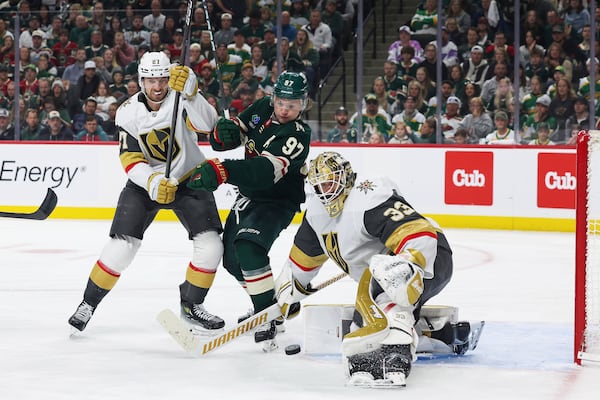 Minnesota Wild left wing Kirill Kaprizov (97) and Vegas Golden Knights defenseman Shea Theodore (27) fight for control of the puck during the third period in Game 4 of an NHL hockey Stanley Cup first-round playoff series, Saturday, April 26, 2025, in St. Paul, Minn. (AP Photo/Stacy Bengs)