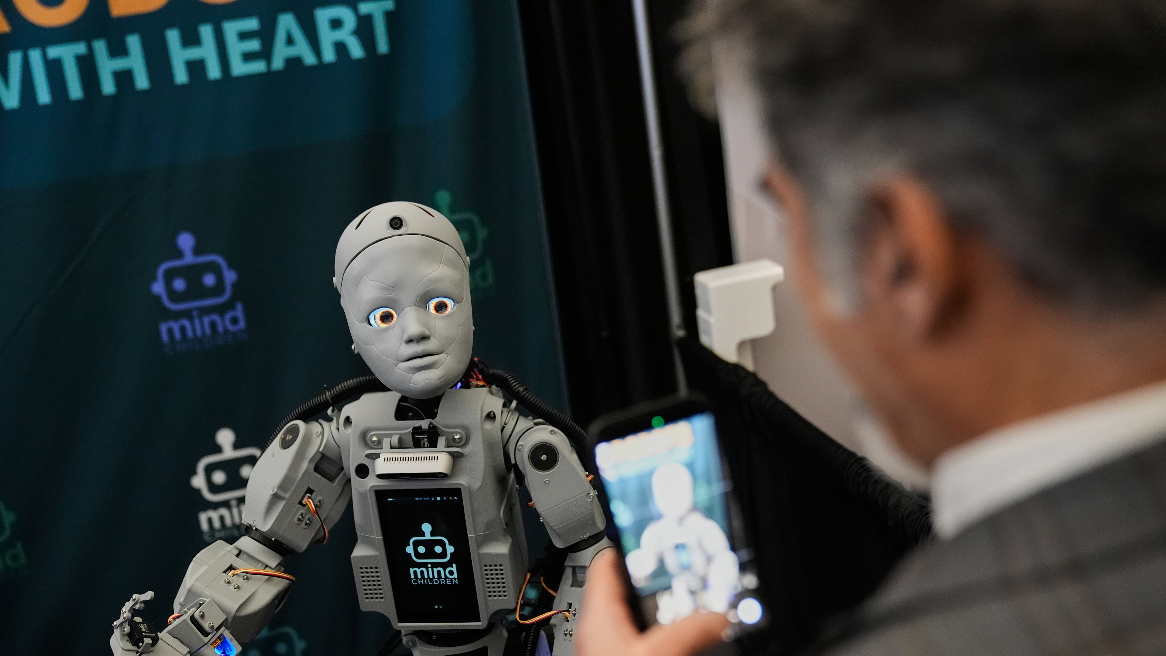 A man records a humanoid robot inside the exhibition room at the Humanoids Summit, Thursday, Dec. 11, 2025, in Mountain View, Calif. (AP Photo/Godofredo A. Vásquez)