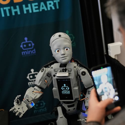 A man records a humanoid robot inside the exhibition room at the Humanoids Summit, Thursday, Dec. 11, 2025, in Mountain View, Calif. (AP Photo/Godofredo A. Vásquez)