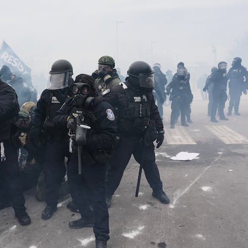Federal immigration officers confront protesters outside Bishop Henry Whipple Federal Building, Thursday, Jan. 15, 2026, in Minneapolis. (AP Photo/Adam Gray)