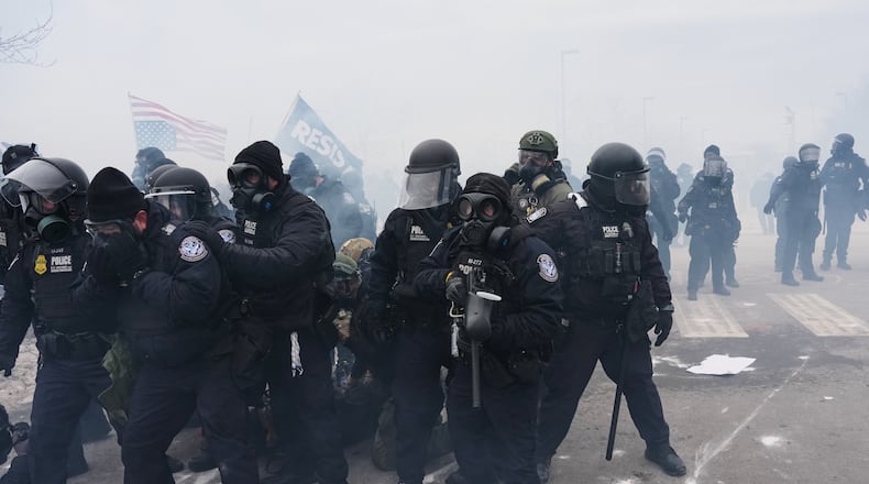 Federal immigration officers confront protesters outside Bishop Henry Whipple Federal Building, Thursday, Jan. 15, 2026, in Minneapolis. (AP Photo/Adam Gray)