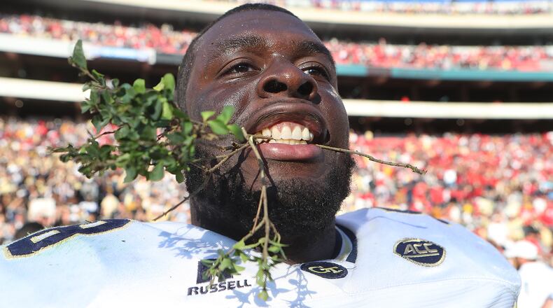 Georgia Tech center Freddie Burden takes a bite out of the hedges savoring a 28-27 victory over Georgia in a NCAA college football rivalry football game on Saturday, Nov. 26, 2016, in Athens. Curtis Compton/ccompton@ajc.com