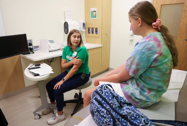Diabetes Educator Justyna Zabinski, left, talks with 11-year-old Elizabeth Thomas of Duluth, who has Type 1 diabetes, about placing an insulin pump on the back of her arm during a visit at the Children’s Healthcare of Atlanta Center for Advanced Pediatrics, Wednesday, June 12, 2024, in Atlanta. Zabinski is one of several full time diabetes educators who also have Type 1 diabetes. (Jason Getz / AJC)
