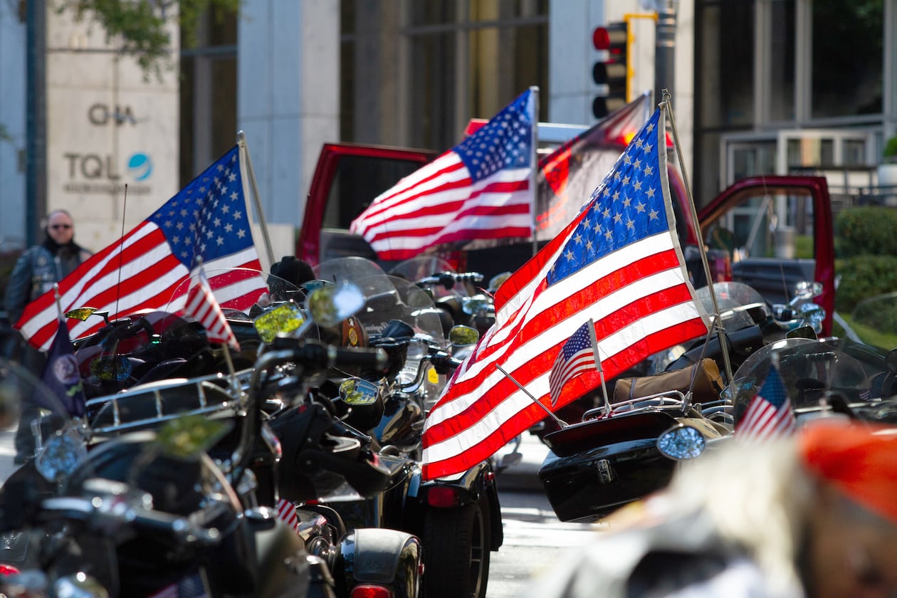 Motorcycles and American flags are lined up on Peachtree Street waiting for the start of a previous Veterans Day Parade in Atlanta. (AJC file)