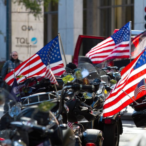 Motorcycles and American flags are lined up on Peachtree Street waiting for the start of a previous Veterans Day Parade in Atlanta. (AJC file)