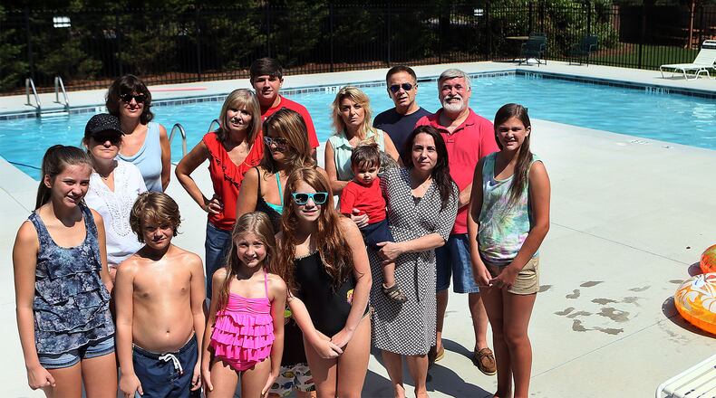 Residents of the Twelvestones neighborhood in Roswell pose by their brand new pool on July 19, 2013. They are upset about a plan to build a 400-foot tall emergency radio tower across the street from their new community pool. They held a door-to-door campaign to raise the funds to replace the neighborhood's aging pool. Now they are concerned about the prospects of a tower looming over their pool.