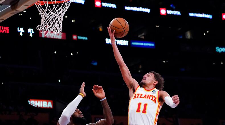 Atlanta Hawks guard Trae Young (11) shoots against Los Angeles Lakers forward LeBron James (6) during the second half of an NBA basketball game in Los Angeles, Friday, Jan. 7, 2022. (AP Photo/Ashley Landis)