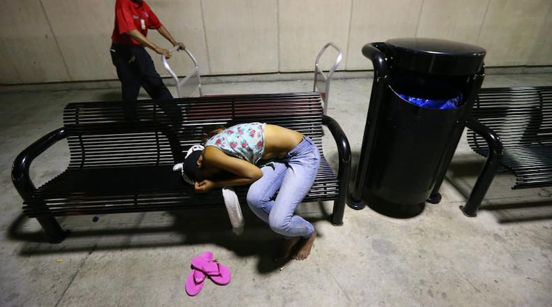 After most flights have concluded for the night a woman sleeps on the bench outside the south baggage claim at Hartsfield-Jackson Atlanta International Airport on Tuesday, Oct. 1, 2013, in Atlanta.