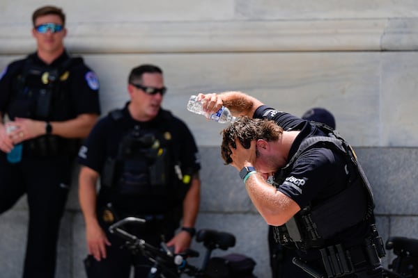A U.S. Capitol Police officer pours water on his head, Wednesday, June 25, 2025, outside the Capitol in Washington. (AP Photo/Julia Demaree Nikhinson)