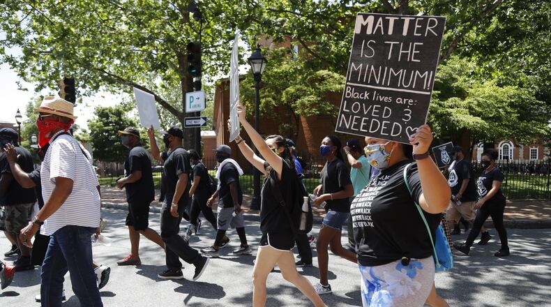 People hold signs while marching through Church Circle, Friday, June 19, 2020 in downtown Annapolis, Md., during Juneteenth 2020 celebration and protest against police brutality. Juneteenth marks the day in 1865 when federal troops arrived in Galveston, Texas, to take control of the state and ensure all enslaved people be freed, more than two years after the Emancipation Proclamation. (AP Photo/Julio Cortez)