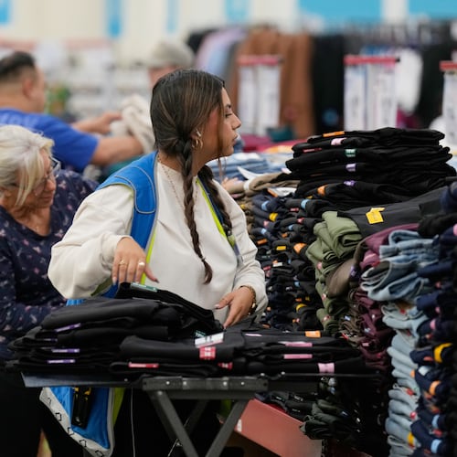 File - A worker stocks a display of clothing at a Sam's Club, Wednesday, Sept. 24, 2025, in Bentonville, Ark. (AP Photo/Charlie Riedel, File)