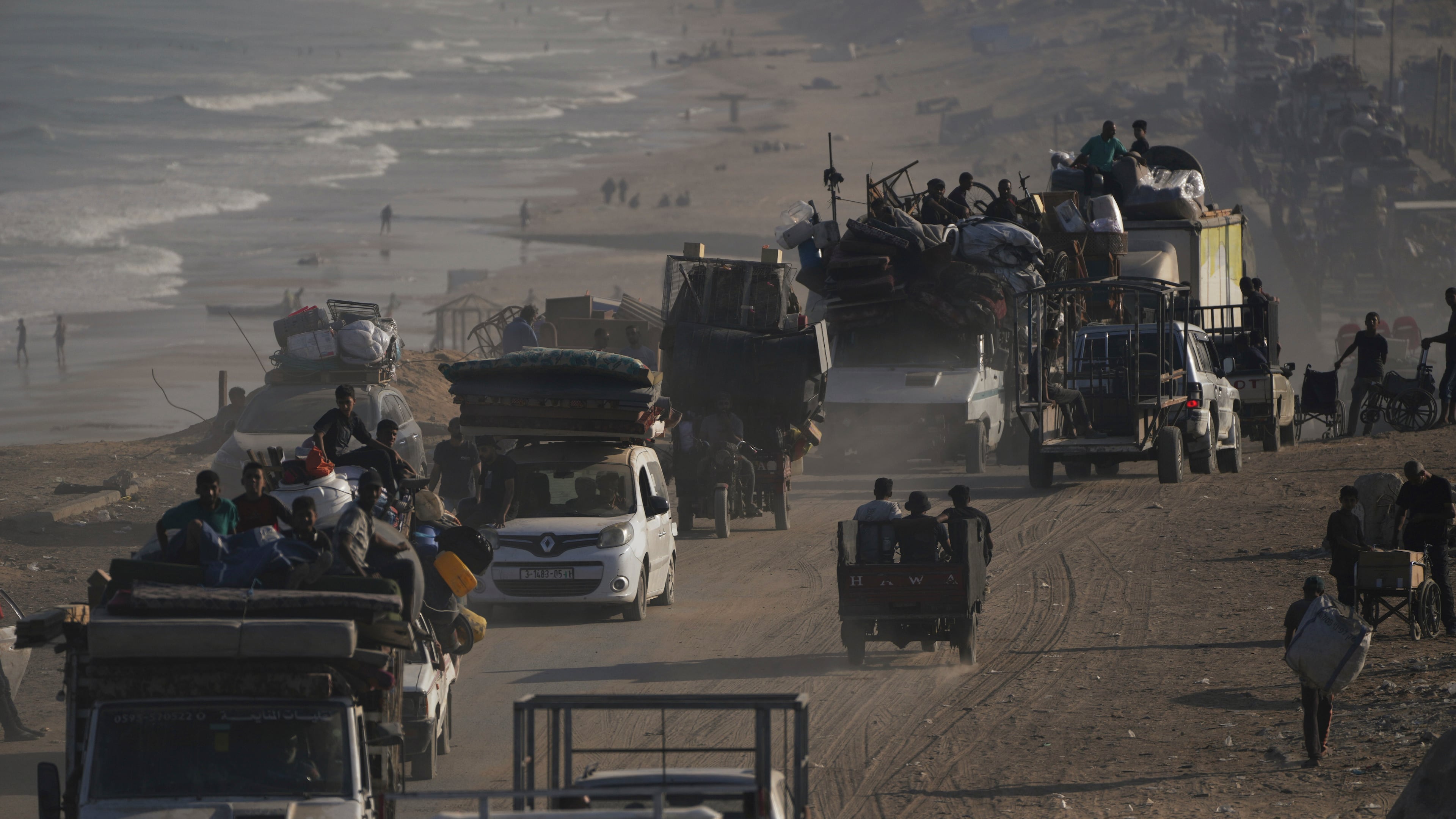 Displaced Palestinians flee Gaza City by foot and vehicles, carrying their belongings along the coastal road toward southern Gaza, Wednesday, Sept. 17, 2025. (AP Photo/Abdel Kareem Hana)