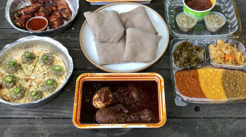 This takeout feast from Feedel Bistro features (clockwise from upper left): awaze wings; minchet abish key wet; vegan sampler; doro wet; azifah on pita; and injera (center). CONTRIBUTED BY WENDELL BROCK