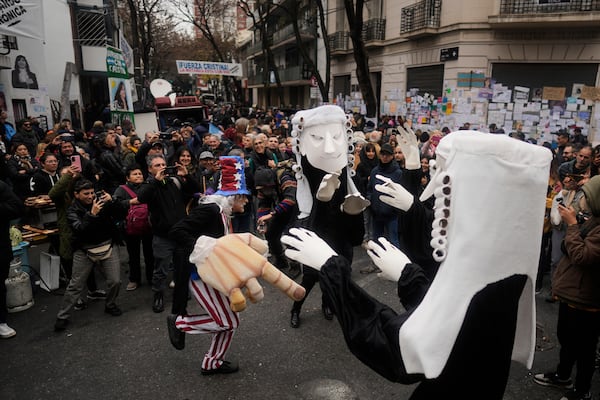 Supporters of Argentina's former President Cristina Fernandez gather outside her home one week after the nation's Supreme Court upheld her corruption conviction in Buenos Aires, Argentina, Tuesday, June 17, 2025. (AP Photo/Natacha Pisarenko)
