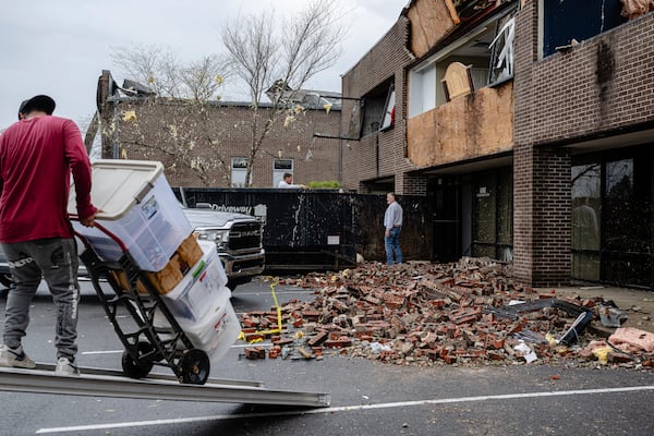 Debris and goods are removed from damaged businesses in the Triad Building, a business plaza, after severe weather passed through Thursday, April 3, 2025, in Louisville, Ky. (AP Photo/Jon Cherry)