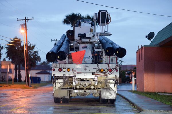 A truck carrying new utility polls is staged for use in preparation of Hurricane Harvey on Friday, Aug. 25, 2017, in Port Isabel, Texas.The National Hurricane Center warns that conditions are deteriorating as Hurricane Harvey strengthens and slowly moves toward the Texas coast. (Jason Hoekema/The Brownsville Herald via AP)