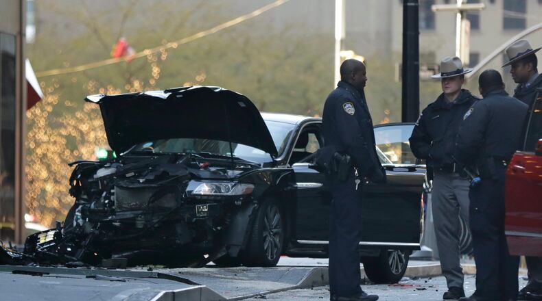 Police gather at the scene of an accident near Broadway and Liberty Street in New York on Thursday, Dec. 7, 2017. Police say six people were hurt in the accident involving three vehicles just blocks from the World Trade Center in Lower Manhattan. (AP Photo/Peter Morgan)