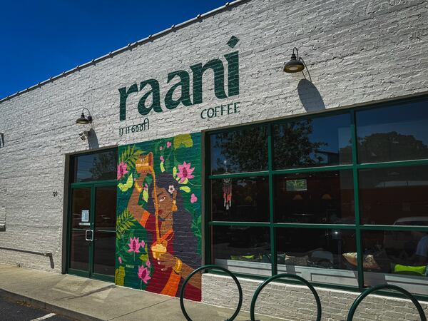 The exterior of a coffee shop with a mural and a painted sign that says Raani.