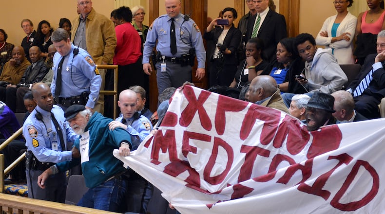 About 20 “Moral Monday” protesters were arrested at the state Capitol in March 2014 after disrupting the Senate by shouting and holding signs calling for Medicaid expansion. Georgia is one of 19 states that has refused to expand Medicaid under the Affordable Care Act. BRANT SANDERLIN /BSANDERLIN@AJC.COM