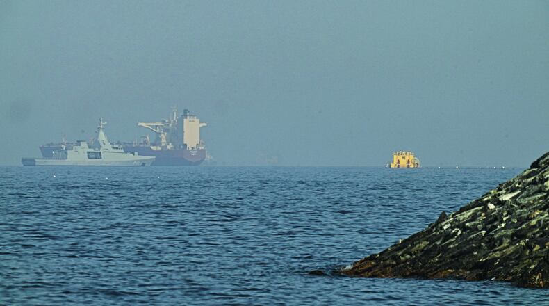 An Emirati patrol boat, left, is near a tanker anchored in the Gulf of Oman near the Strait of Hormuz, as seen from a coastal road near Khor Fakkan, United Arab Emirates, Friday, May 1, 2026. (AP Photo/Fatima Shbair)