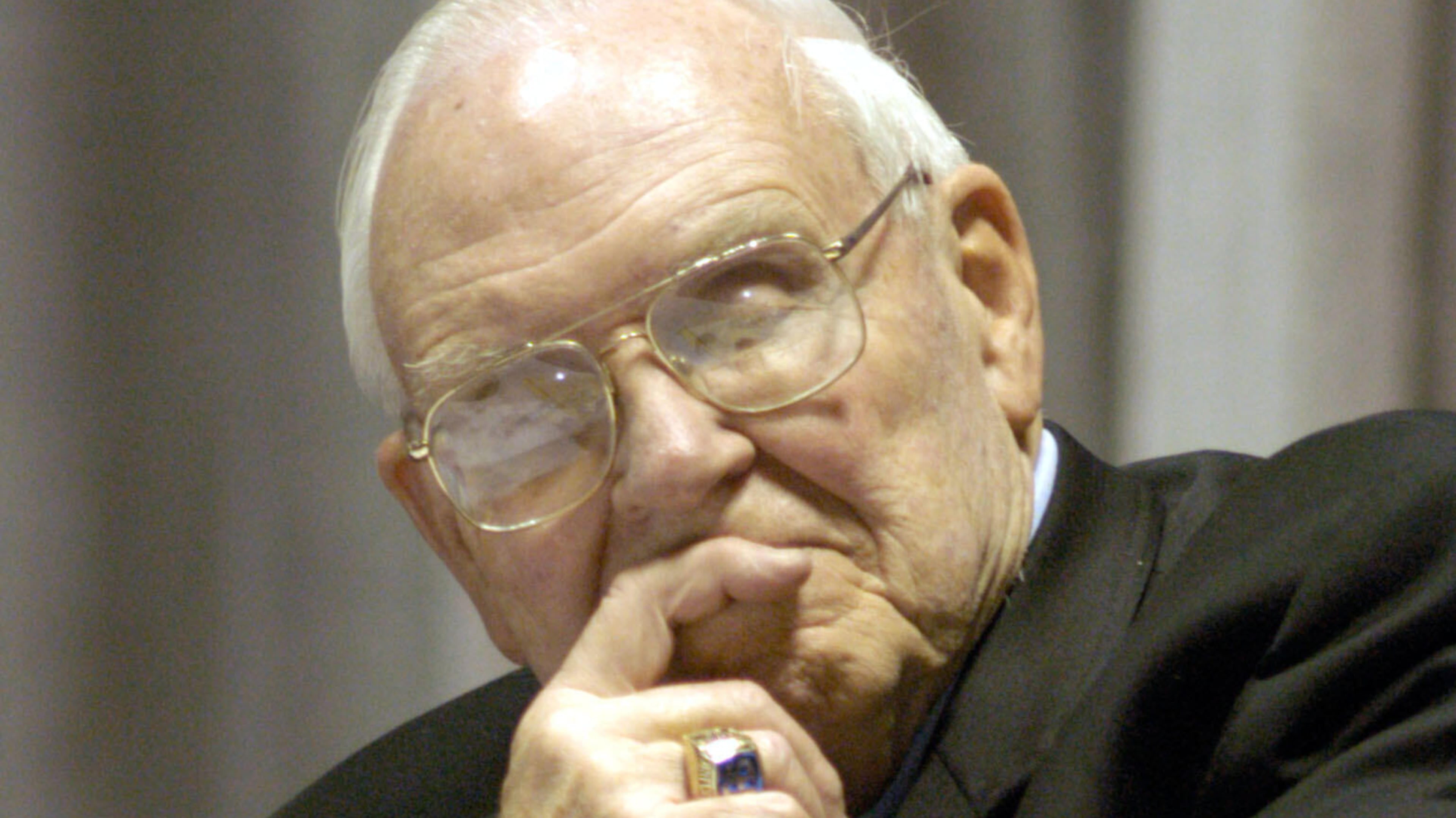 FILE - Roy Kramer, former commissioner , Southeastern Conference, listens to Mack Brown, Head Football Coach for The University of Texas, during his opening statement for the panel discussion for "Ethical Issues in College Athletics" in the Daniel-Meyer Coliseum on the Texas Christian University Campus, Thursday, Feb., 12, 2004. (AP Photo/David Pellerin, File)