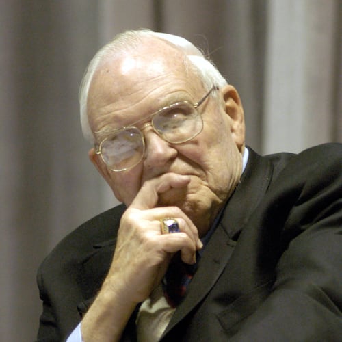 FILE - Roy Kramer, former commissioner , Southeastern Conference, listens to Mack Brown, Head Football Coach for The University of Texas, during his opening statement for the panel discussion for "Ethical Issues in College Athletics" in the Daniel-Meyer Coliseum on the Texas Christian University Campus, Thursday, Feb., 12, 2004. (AP Photo/David Pellerin, File)