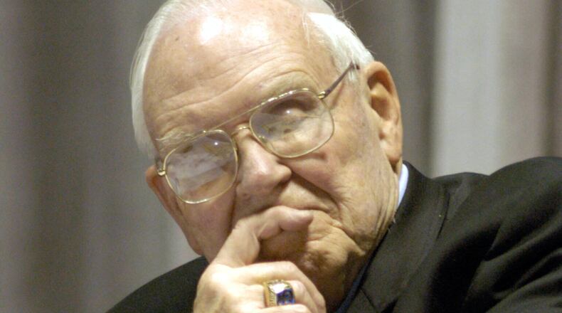 FILE - Roy Kramer, former commissioner , Southeastern Conference, listens to Mack Brown, Head Football Coach for The University of Texas, during his opening statement for the panel discussion for "Ethical Issues in College Athletics" in the Daniel-Meyer Coliseum on the Texas Christian University Campus, Thursday, Feb., 12, 2004. (AP Photo/David Pellerin, File)