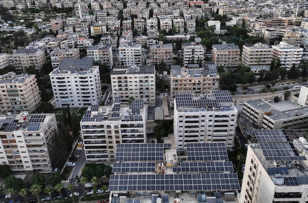 An aerial view shows solar panels installed on building rooftops in Damascus, Syria, Monday, June 30, 2025. (AP Photo/Ghaith Alsayed)