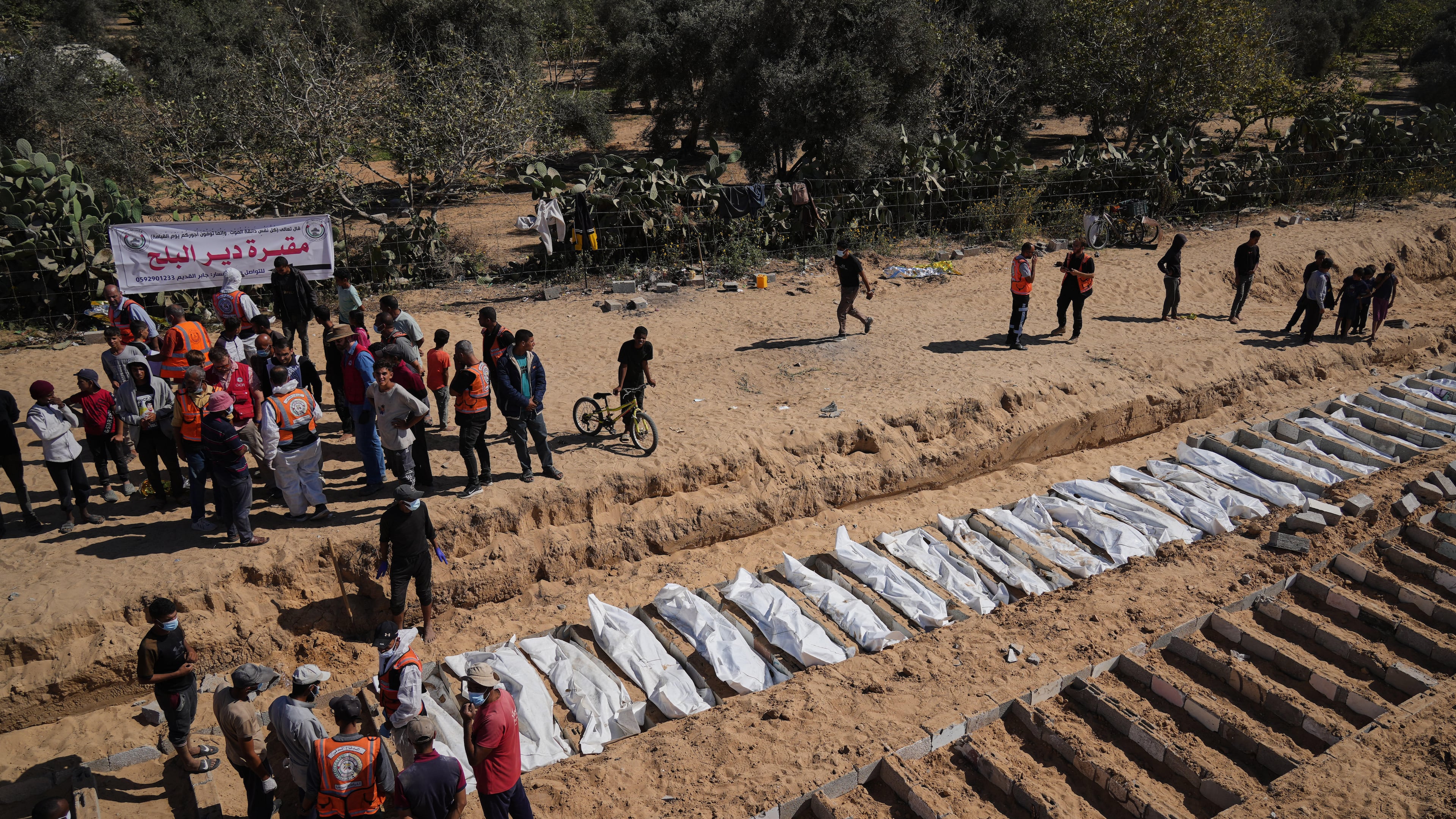 Bodies of unidentified Palestinians returned from Israel are buried in a mass grave in Deir al-Balah, Gaza Strip, Monday, Oct. 27, 2025. (AP Photo/Jehad Alshrafi)
