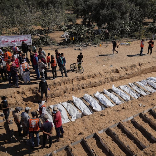 Bodies of unidentified Palestinians returned from Israel are buried in a mass grave in Deir al-Balah, Gaza Strip, Monday, Oct. 27, 2025. (AP Photo/Jehad Alshrafi)