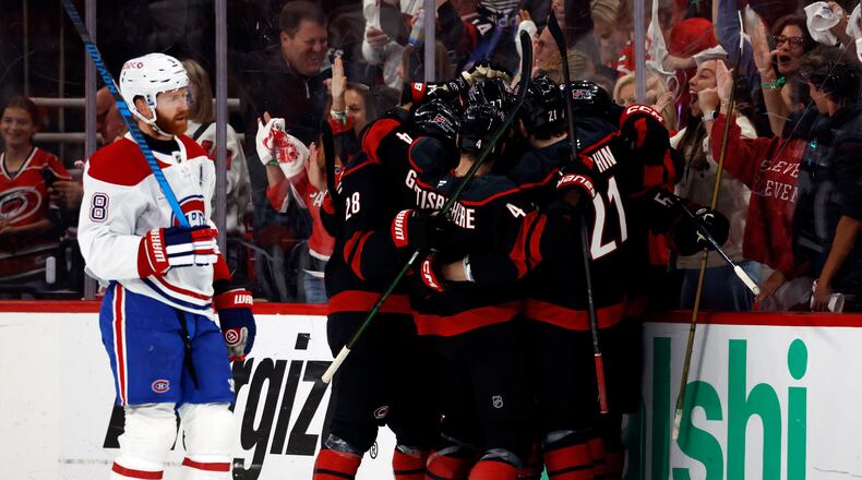 Carolina Hurricanes players celebrate after a goal by Eric Robinson as Montreal Canadiens' Mike Matheson (8) skates by during the first period in Game 5 of the Eastern Conference finals NHL hockey Stanley Cup playoff series in Raleigh, N.C., Friday, May 29, 2026. (AP Photo/Karl DeBlaker)