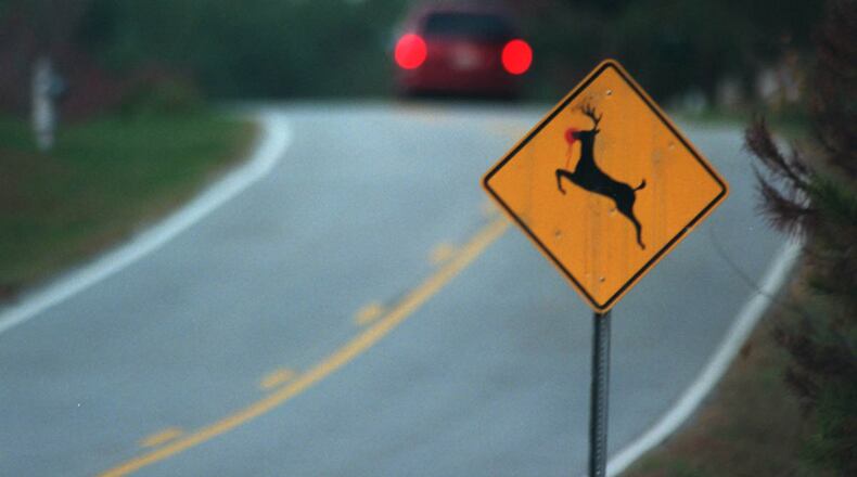A car drives past a deer crossing sign on Tucker Mill Road. The chances of an auto-deer collision more than double in October, November and December. File / staff