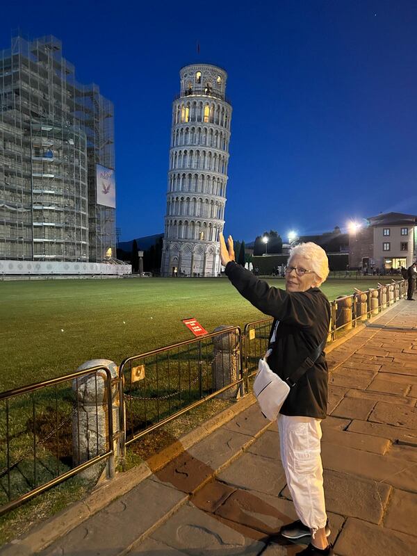 Former Cobb County school teacher Kay Braswell is pointing to the site of one of her latest travel adventures. She loves traveling and climbed the Leaning Tower of Pisa in Italy to mark her 80th birthday in April. (Courtesy of Kay Braswell)