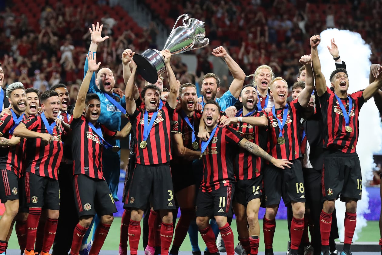 Atlanta United players hoist the Lamar Hunt trophy after defeating Minnesota United 2-1 to win the U.S. Open Cup on Tuesday, Aug. 27, 2019, in Atlanta. (Curtis Compton/AJC)