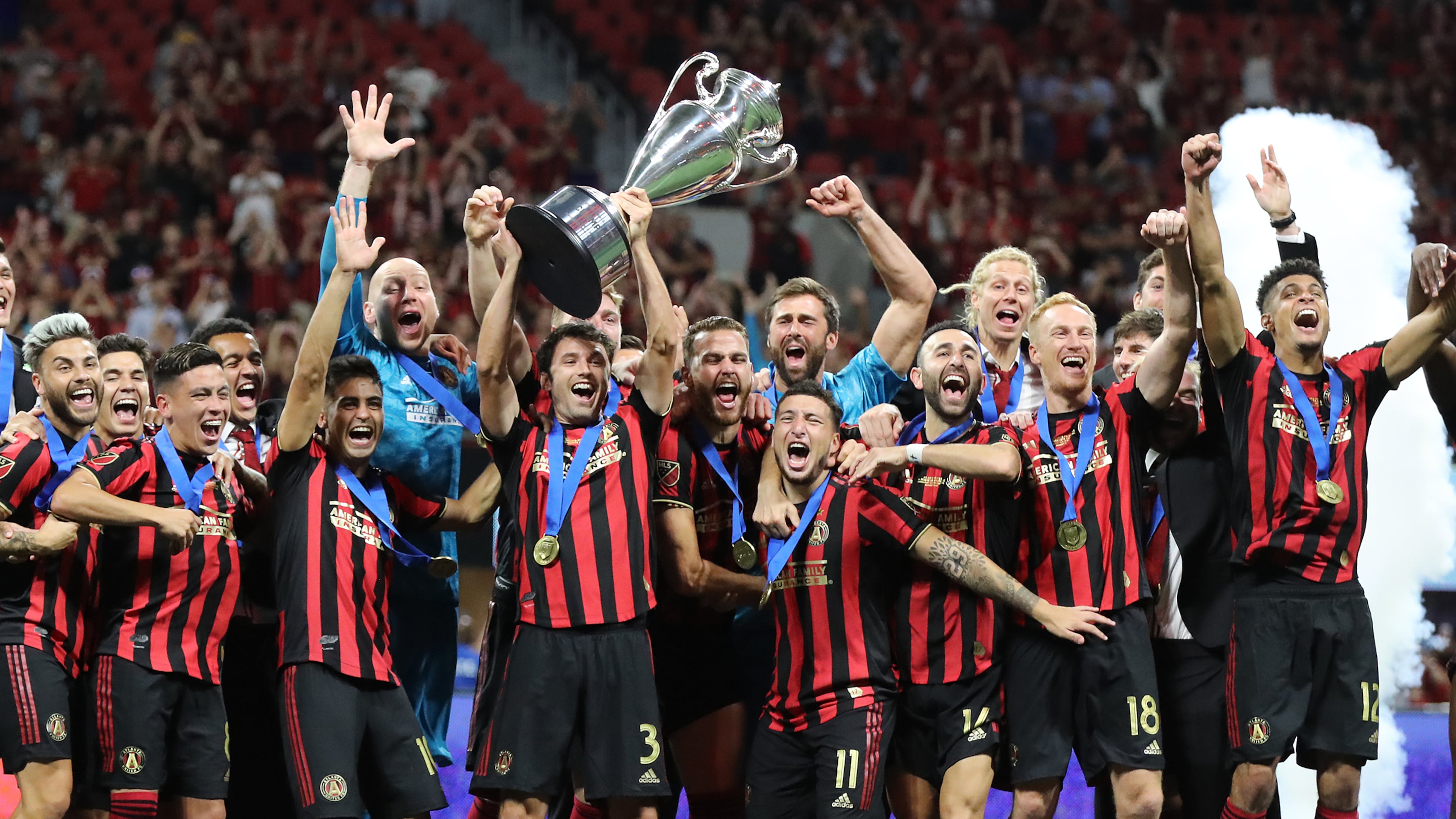 Atlanta United players hoist the Lamar Hunt trophy after defeating Minnesota United 2-1 to win the U.S. Open Cup on Tuesday, Aug. 27, 2019, in Atlanta. (Curtis Compton/AJC)