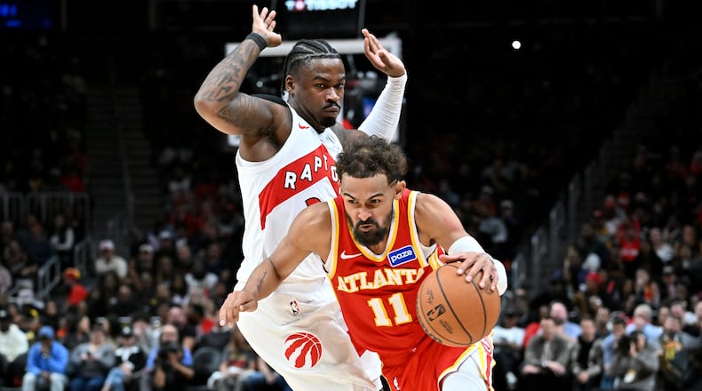 Atlanta Hawks guard Trae Young (11) drives past Toronto Raptors guard Jamal Shead during the second half in the home opener at State Farm Arena, Thursday, October 22, 2025, in Atlanta. The Raptors won 138-118 over the Hawks. (Hyosub Shin/AJC)