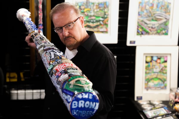 Charles Fazzino poses with one of his edgy baseball bats inside the Capital One All-Star Village at Cobb Galleria. What keeps Fazzino as the official MLB All-Star Game artist is building fans in cities that might not be familiar with his work: “When people see it, it’s uniquely me.”(Abbey Cutrer/AJC)