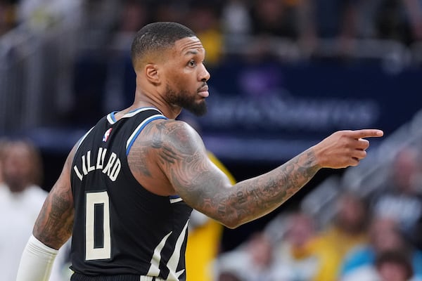 Milwaukee Bucks guard Damian Lillard (0) gestures after a three-point basket against the Indiana Pacers during the second half of a first-round NBA basketball playoff game in Indianapolis, Tuesday, April 22, 2025. (AP Photo/Michael Conroy)