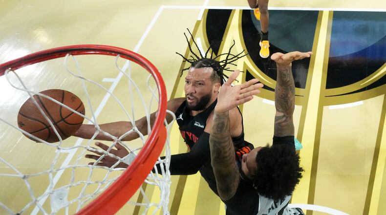 New York Knicks guard Jalen Brunson, left, shoots the ball past San Antonio Spurs forward Julian Champagnie (30) during an NBA Cup championship basketball game, Tuesday, Dec. 16, 2025, in Las Vegas. (Kirby Lee/Pool Photo via AP)