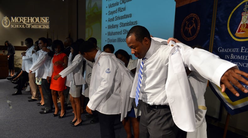 MEDICAL STUDENT TRADITION--First year medical student Dorian Wood dons his white coat during the Morehouse School of Medicine Annual White Coat Ceremony in this AJC file photo. MSM is one of four Black medical schools in the U.S.