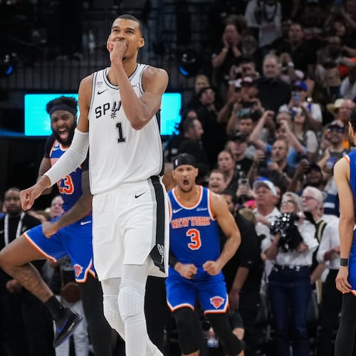San Antonio Spurs forward Victor Wembanyama walks off the court as time expires during the second half of Game 2 of the NBA Finals basketball series as New York Knicks guard Landry Shamet (44), guard Josh Hart (3), and center Mitchell Robinson (23) celebrate, Friday, June 5, 2026, in San Antonio. (AP Photo/Eric Gay)
