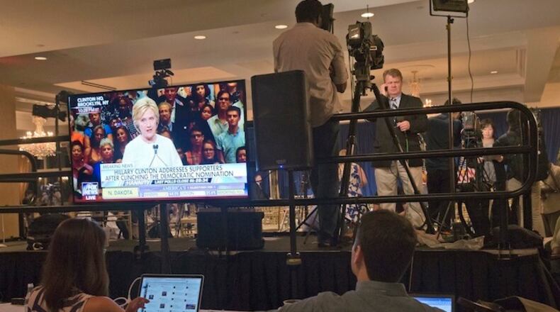 Democratic presidential candidate Hillary Clinton is seen on a television screen addressing her supporters as reporters file their stories after a news conference by Republican presidential candidate Donald Trump at the Trump National Golf Club Westchester, Tuesday, June 7, 2016, in Briarcliff Manor, N.Y. ( Photo/Mary Altaffer)