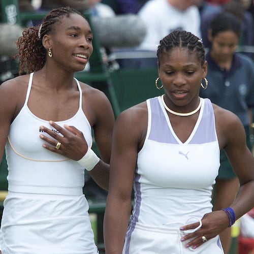 FILE -Venus Williams, left, and sister Serena talk together, during their Women's Doubles match against Irina Spirlea and Caroline Vis, at Wimbledon, July 4, 2000. (AP Photo/Alastair Grant, File)