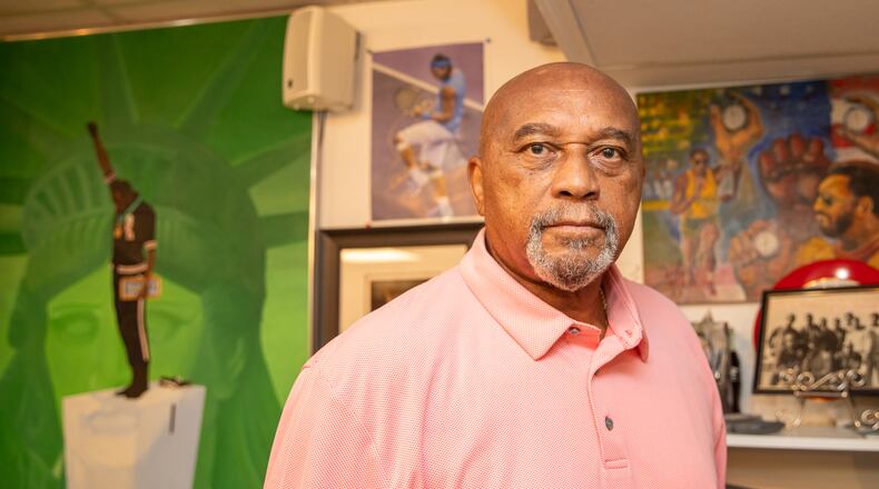 Tommie Smith, who raised his fist in protest during the 1968 Olympics awards ceremony after winning the 200-meter sprint in Mexico City, shows off some of the memorabilia at his Stone Mountain home. Smith will speak about his life and his new graphic memoir, “Victory. Stand," at Ebenezer Baptist Church on Oct. 8. (Jenni Girtman for The Atlanta Journal-Constitution)