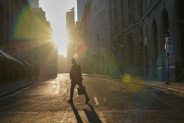 A man walks in the the City of London financial district, London, Tuesday, April 8, 2025. (AP Photo/Alberto Pezzali)