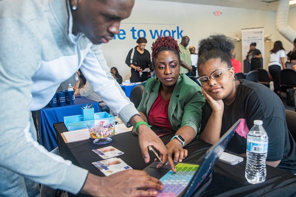 Karen Mitchell, (center), CEO of Justin Global Solutions LLC interacts with job seekers at a job fair hosted by Goodwill Career Center in Atlanta on Tuesday, July 9, 2024.  (Ziyu Julian Zhu / AJC)
